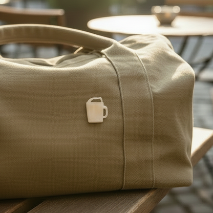 より小さなブローチをつけたカーキバッグ